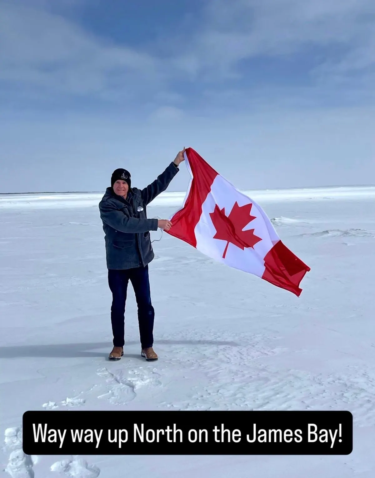 Gaétan Malette holding a Canadian flag on the frozen James Bay