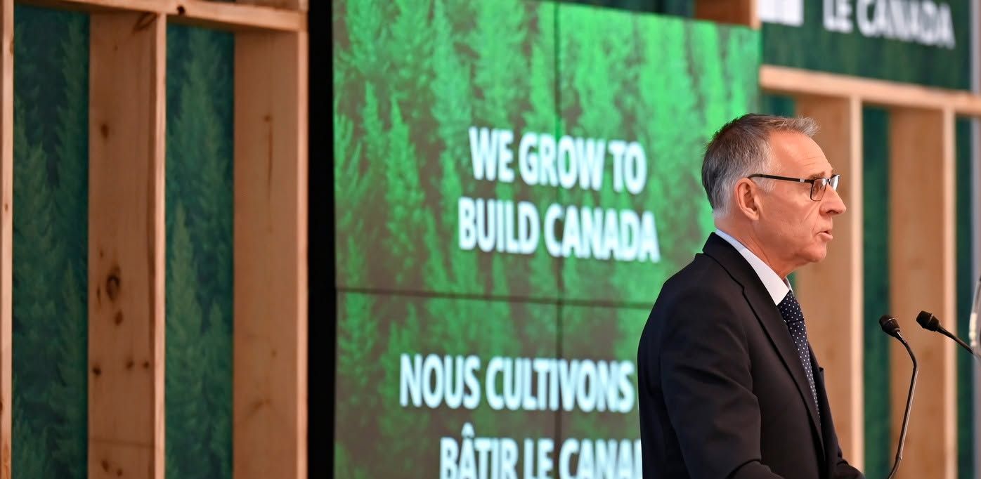 Gaétan Malette speaking at a podium in front of a We Grow to Build Canada backdrop